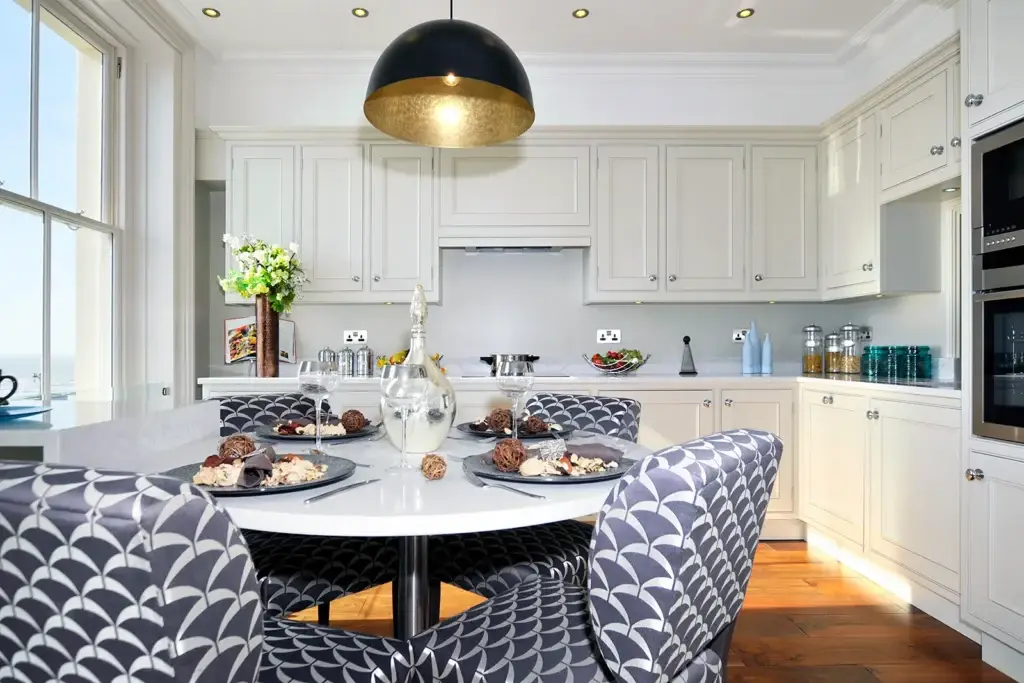 Handmade kitchen in Worthing with built-in cabinetry, coastal dining setting, and bespoke shaker-style finish by Downland & Scullery