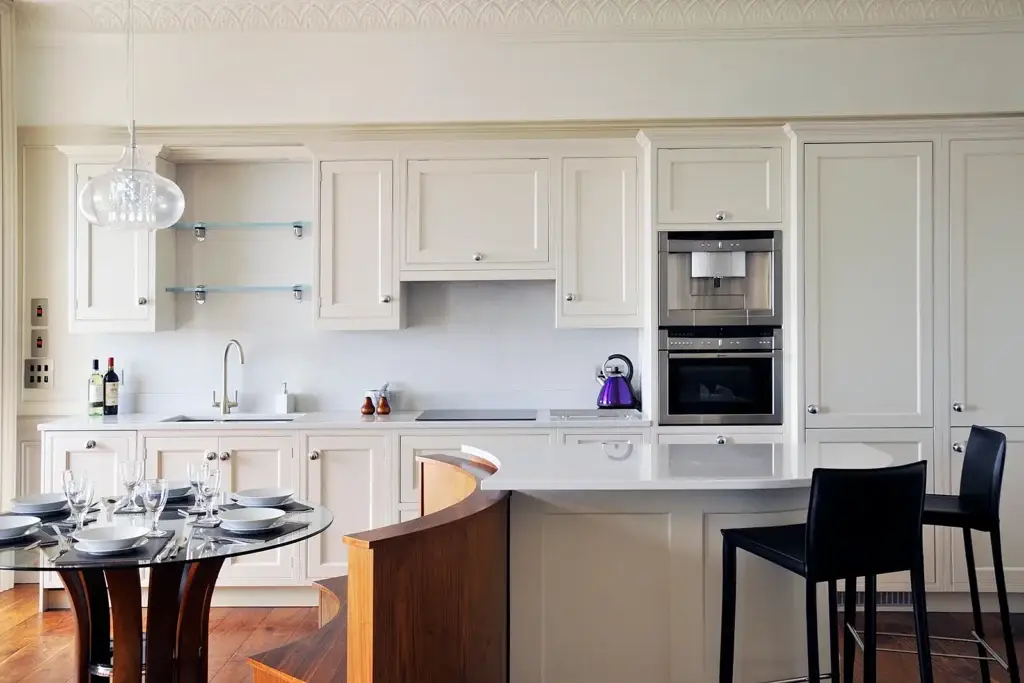 Handmade kitchen in Worthing featuring classic cabinetry, integrated appliances, and bespoke curved breakfast bar by Downland & Scullery